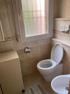 een badkamer met een toilet, een wastafel en een raam bij Appartamento giardino in Rapallo
