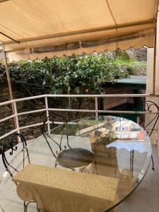 een glazen tafel en stoelen op een balkon bij Appartamento giardino in Rapallo