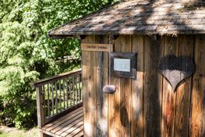 a wooden cabin with a sign and a heart on it at Hotel Tann in Collalbo