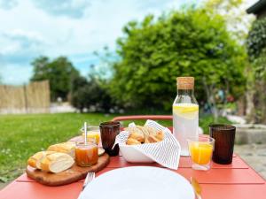 a table with a plate of bread and a bottle of orange juice at Bayda's Tiny House in Sprimont