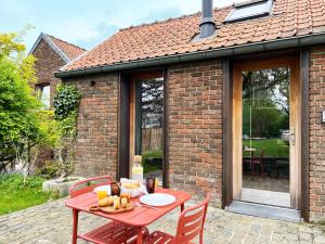 ein roter Tisch und Stühle auf einer Terrasse in der Unterkunft Bayda's Tiny House in Sprimont + 36 Fotos