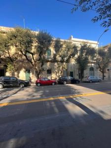 a street with cars parked in front of a building at La Nuotatrice in Lecce