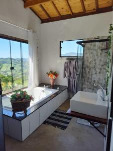 a large bathroom with a tub and a sink at Pousada Vitoria in Gonçalves +53 photos