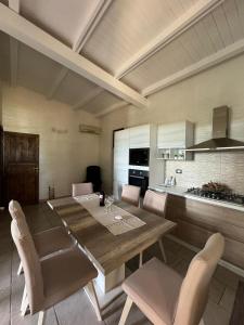 een eetkamer met een tafel en stoelen en een keuken bij Desiree Casa Vacanze in Avola
