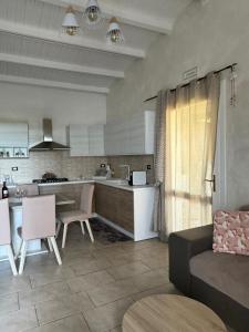 a kitchen and living room with a couch and a table at Desiree Casa Vacanze in Avola +4 photos