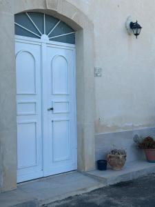 eine weiße Tür an der Seite eines Gebäudes in der Unterkunft Desiree Casa Vacanze in Avola + 13 Fotos