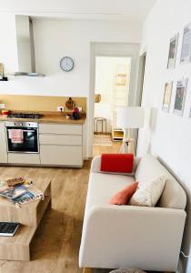 ein Wohnzimmer mit einem weißen Sofa und einer Küche in der Unterkunft Nuovo appartamento Castiglione in Castiglione della Pescaia
