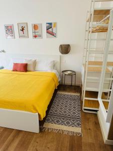 ein Schlafzimmer mit einem gelben Bett und einer Leiter in der Unterkunft Nuovo appartamento Castiglione in Castiglione della Pescaia