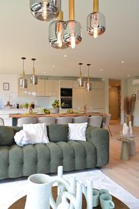 sala de estar con sofá verde y cocina en Extraordinaire Villa 5 étoiles 12 personnes 7 min Lille en Marcq-en-Baroeul