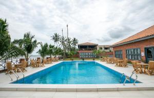 a swimming pool with chairs and a building at Mankoview Beach Resort in Winneba