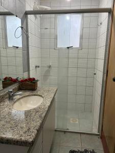 uma casa de banho com uma cabina de duche em vidro e um lavatório. em THERMAS DO BANDEIRANTE em Caldas Novas