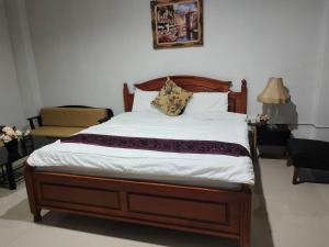 a bed with a wooden frame in a bedroom at the rich room ห้องพักนครราชสีมาใกล้เซ็นทรัล in Ban Pra Dok