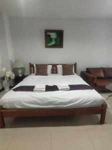 duże łóżko w pokoju z kanapą w obiekcie the rich room ห้องพักนครราชสีมาใกล้เซ็นทรัล w mieście Ban Pra Dok
