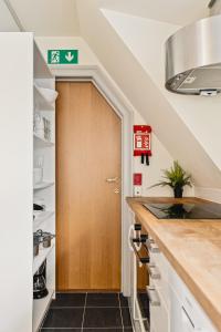 ベルゲンにあるDinbnb Apartments I Shopping, Cafés And Attractions At Your Doorstep!の木製のドアのある階段付きのキッチン