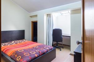 um quarto com uma cama, uma secretária e uma cadeira em Vale Formoso Guest House em Porto