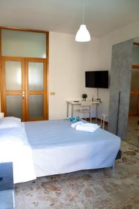 um quarto com uma grande cama branca e uma secretária em Guest House Gobetti em Reggio Emilia