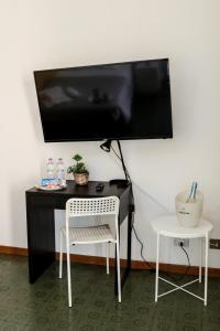 uma secretária com uma televisão numa parede com uma cadeira em Guest House Gobetti em Reggio Emilia