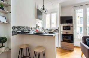 een keuken met een aanrecht en krukken in een kamer bij 678 Suite Raspail - Superbe Appartement in Levallois-Perret