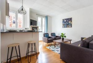 een woonkamer en een keuken met een bank en een tafel bij 678 Suite Raspail - Superbe Appartement in Levallois-Perret