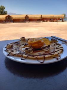 einen Teller mit Obst auf dem Tisch in der Unterkunft Sayal Camp in Taba