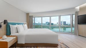 EVEN Hotel Yinchuan Yuehai, an IHG Hotel في ينشوان: غرفة نوم بسرير ابيض كبير ونافذة كبيرة
