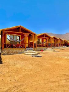 a row of wooden huts in the desert at Sayal Camp in Taba