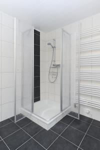 ベンサージールにあるFerienhaus Windlichtの白いタイル張りのバスルーム(シャワーブース付)