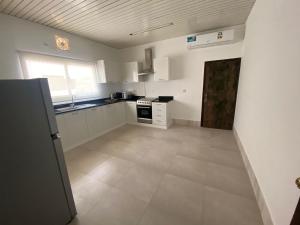 a large kitchen with white cabinets and appliances at Flamingo Cottages in Manama