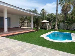a backyard with a swimming pool and a gazebo at Flamingo Cottages in Manama