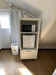 une étagère blanche avec un four micro-ondes. dans l'établissement Palmar Rooms, à Funchal