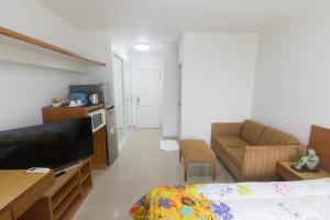 a room with a bed and a couch and a television at Condo I -House Laguna Garden RCA - Behind Sukhumvit-Outer CBD in Bangkok