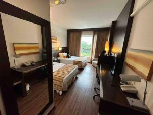 a hotel room with two beds and a mirror at Suíte em hotel de luxo Savassi in Belo Horizonte +11 photos