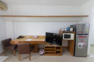 a room with a desk and a microwave and a refrigerator at Condo I -House Laguna Garden RCA - Behind Sukhumvit-Outer CBD in Bangkok
