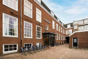un gruppo di biciclette parcheggiate fuori da un edificio di mattoni di Citadines Canal Amsterdam ad Amsterdam