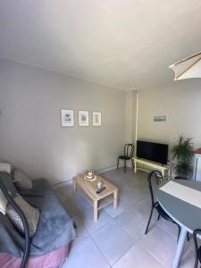 sala de estar con sofá y mesa en La maison de la mer en Merville-Franceville-Plage