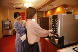two women are standing in front of a microwave at 有馬 瑞宝園 in Kobe