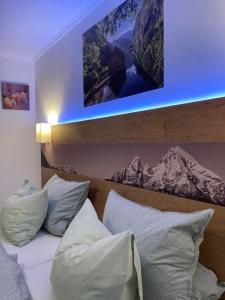 een bed met witte kussens en een foto erboven bij Ferienwohnung Hoamatl in Königssee in Schönau am Königssee