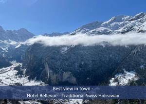 a view of a snow covered mountain with clouds at Hotel Bellevue - Traditional Swiss Hideaway in Wengen