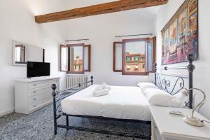 a white bedroom with a bed and a television at Ca' Canciani in Venice