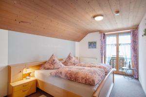 a bedroom with a bed and a large window at Ferienhof 'beim Wendlar' in Bad Hindelang