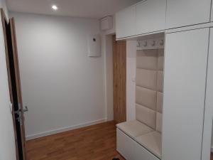 a small kitchen with white cabinets and a closet at Apartmán centrum Bytča. in Bytča