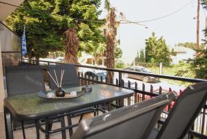 een tafel en stoelen op een balkon met een laptop bij The fir trees house - Το σπίτι με τα έλατα in Litóchoron