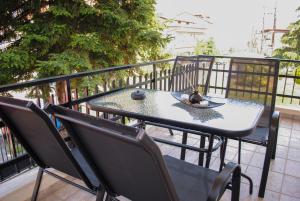 een tafel en stoelen op een balkon bij The fir trees house - Το σπίτι με τα έλατα in Litóchoron