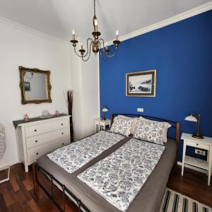 a blue bedroom with a bed and a mirror at M4You in Zagreb