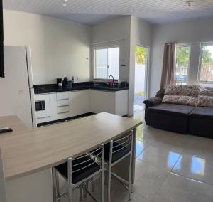 a kitchen and living room with a table and a couch at Casa Cataratas in Foz do Iguaçu