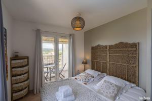 1 dormitorio con 1 cama grande y balcón en Paomia, en Grosseto-Prugna