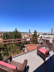 a balcony with chairs and a view of a city at Belgrade View Senjak in Senjak (historical)