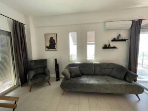 - un salon avec un canapé vert et une chaise dans l'établissement Seaview Apartment, à Saranda
