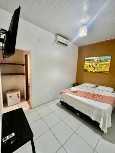 a bedroom with a bed and a flat screen tv at Pousada Meu Xodó in Jericoacoara