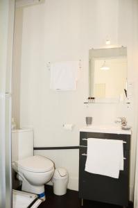 La salle de bains est pourvue de toilettes, d'un lavabo et d'un miroir. dans l'établissement Hôtel L'Oustaou, au Lavandou